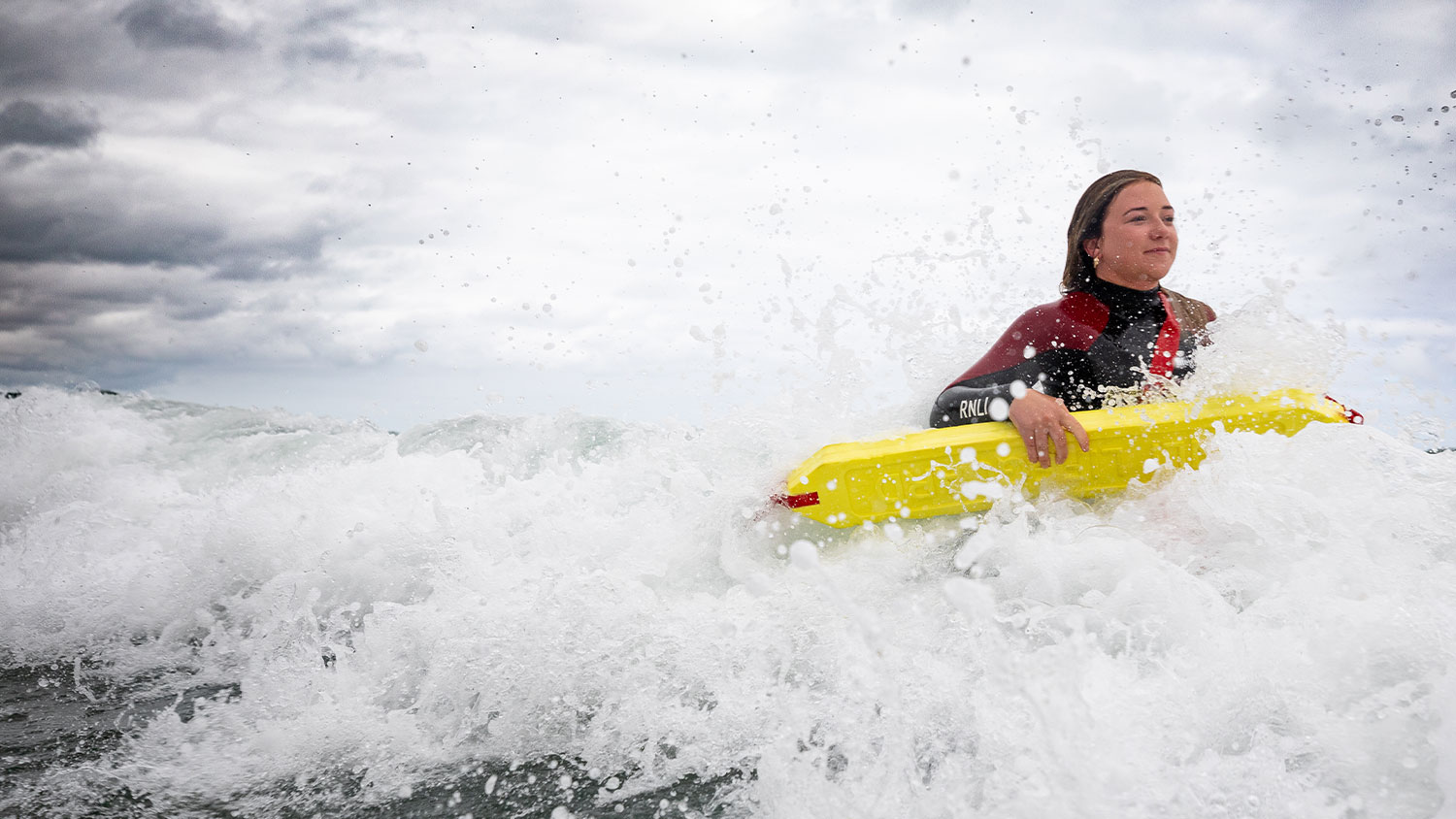 RNLI Lifeguard coming out of the surf with a lifesaver board